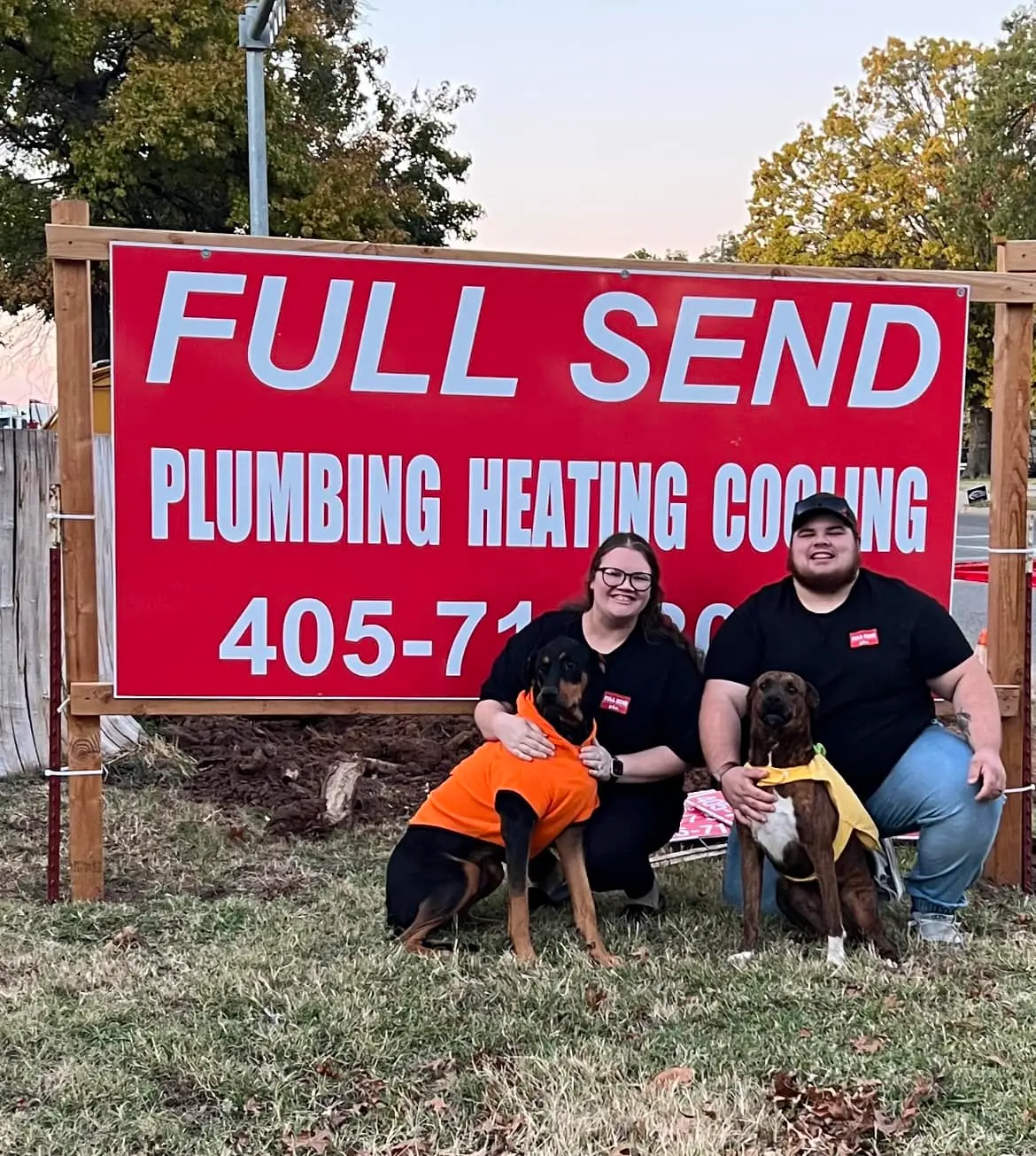 Full Send Plumbing Heating Cooling owners with dogs in front of business sign in Perkins OK